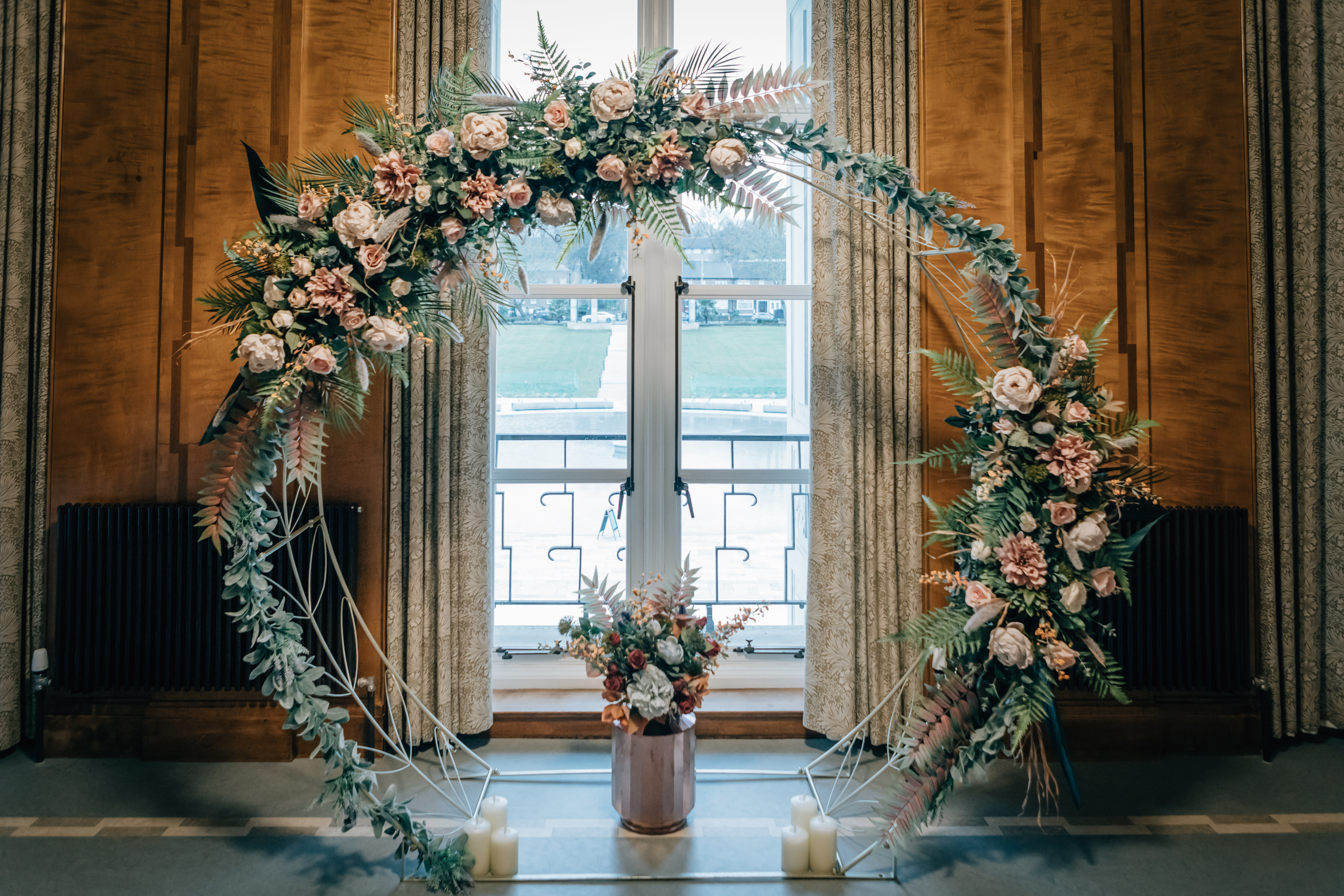 photograph of flower arch in front of window 